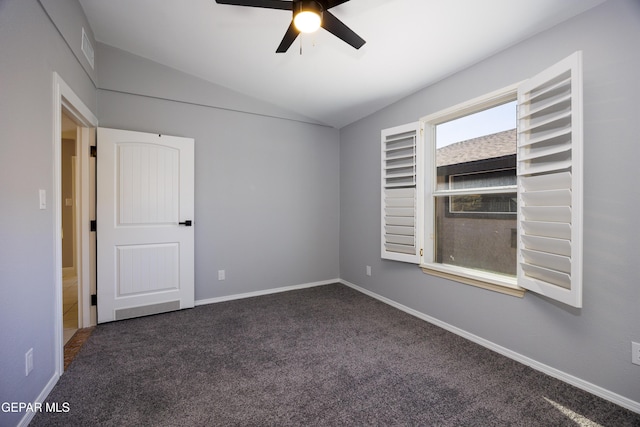 spare room featuring ceiling fan, lofted ceiling, and dark carpet