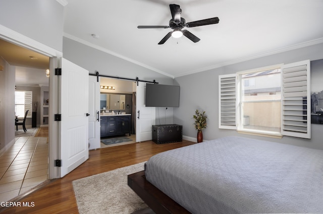 bedroom featuring vaulted ceiling, a barn door, ornamental molding, and dark hardwood / wood-style flooring