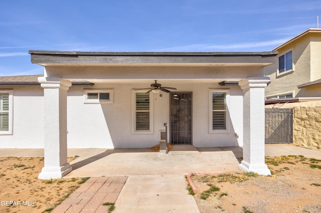 view of exterior entry featuring ceiling fan and a patio area