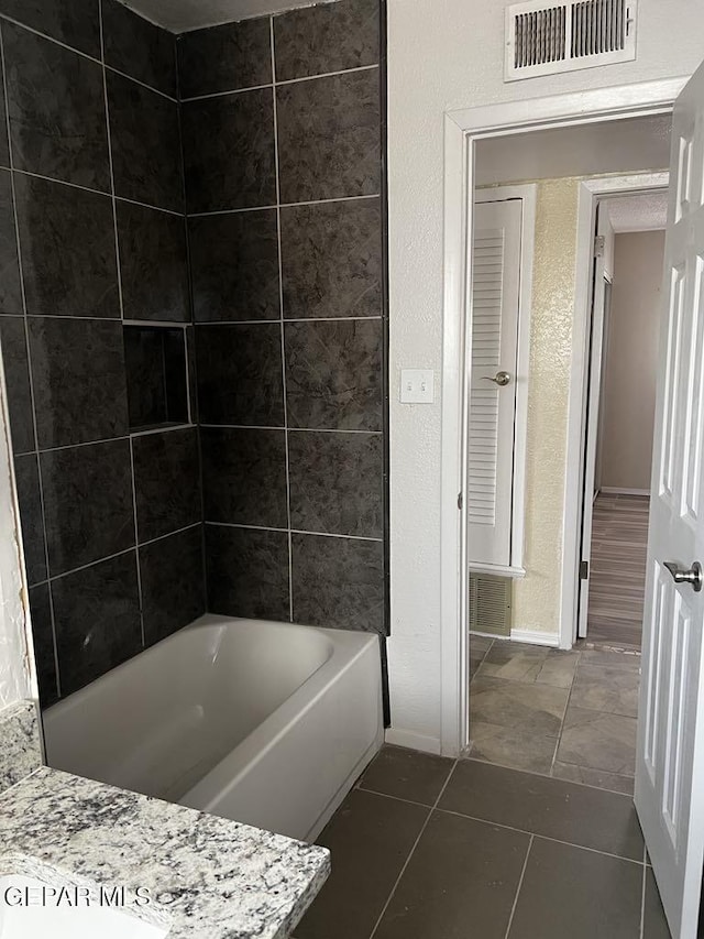 bathroom featuring tile patterned flooring and tiled shower / bath combo