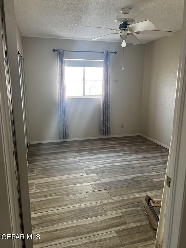 unfurnished room with hardwood / wood-style floors, a textured ceiling, and ceiling fan