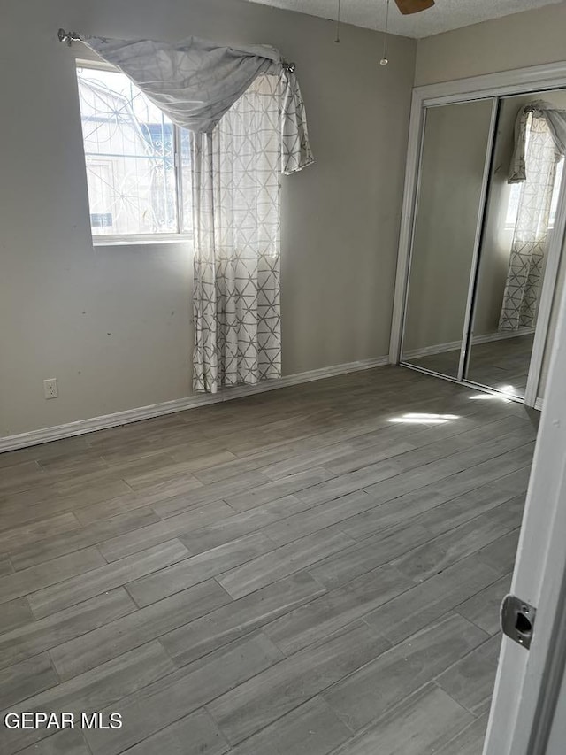 unfurnished bedroom with wood-type flooring and a closet