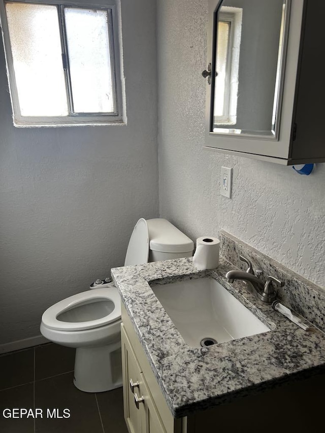 bathroom with vanity, toilet, and tile patterned flooring