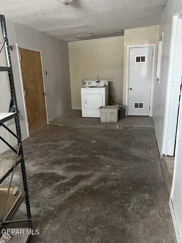 washroom with washer / clothes dryer and a textured ceiling