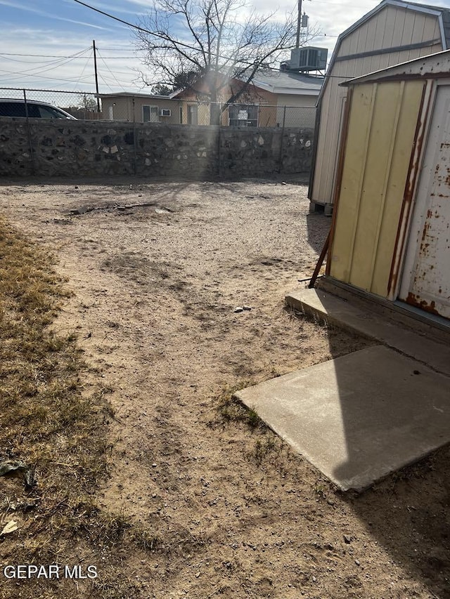 view of yard with cooling unit and a storage shed