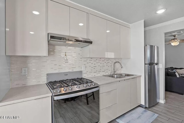 kitchen featuring sink, crown molding, appliances with stainless steel finishes, ceiling fan, and decorative backsplash