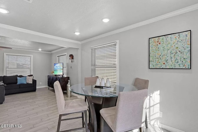 dining space featuring crown molding, a textured ceiling, and light wood-type flooring