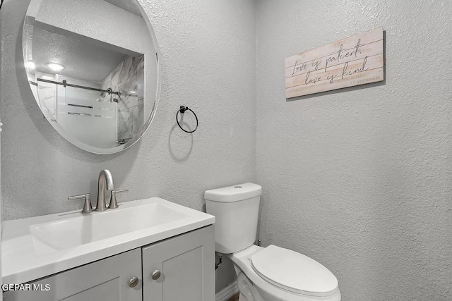 bathroom with vanity, a shower, and toilet