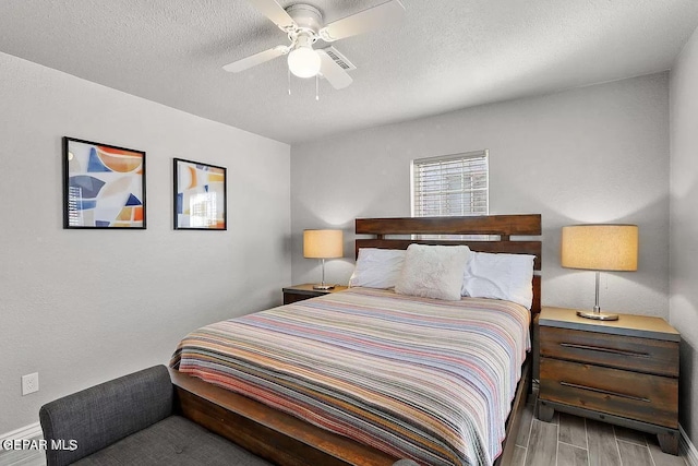 bedroom with hardwood / wood-style floors, a textured ceiling, and ceiling fan