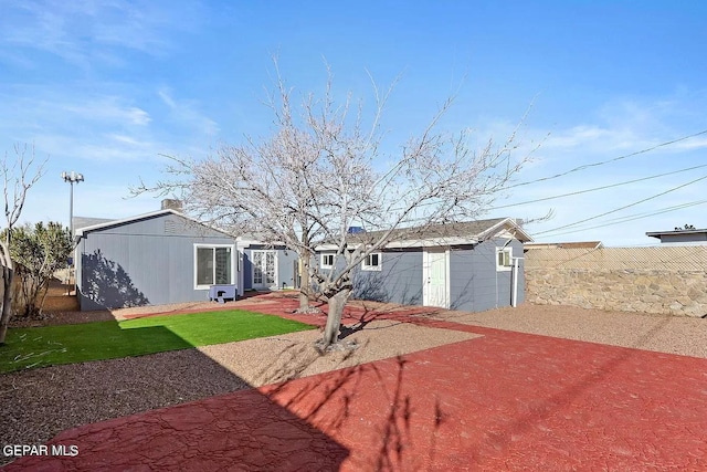 back of property with an outbuilding and a patio