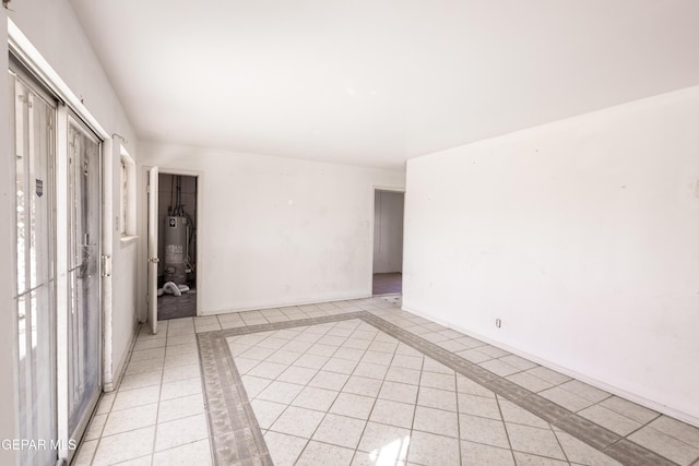 empty room with water heater and light tile patterned floors