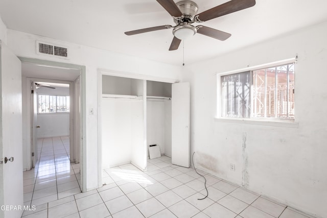 unfurnished bedroom with light tile patterned floors, a closet, and ceiling fan