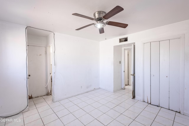 unfurnished bedroom with light tile patterned flooring, ceiling fan, and a closet