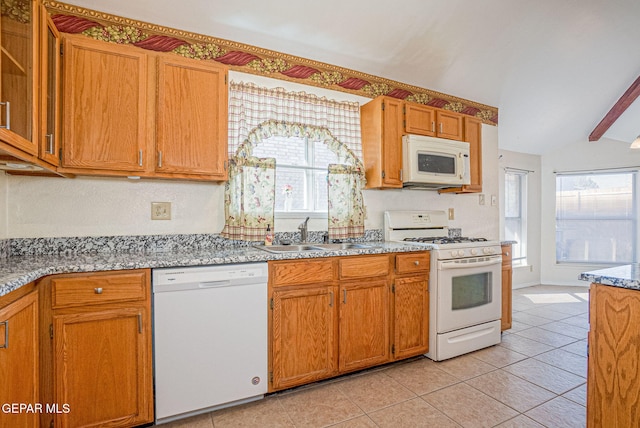 kitchen with sink, lofted ceiling with beams, light tile patterned floors, white appliances, and light stone countertops