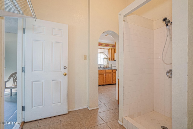 bathroom with tile patterned flooring and tiled shower