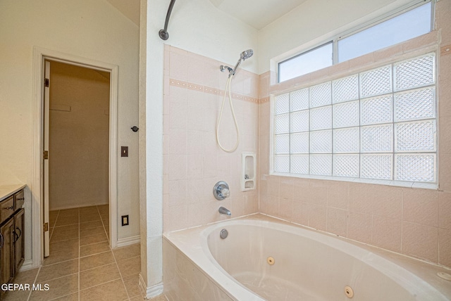 bathroom with tile patterned flooring, vanity, and tiled shower / bath