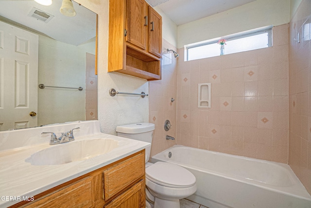 full bathroom with vanity, tiled shower / bath combo, and toilet