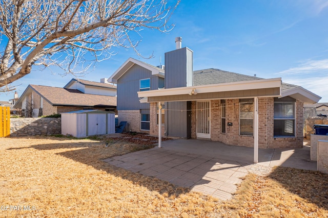 rear view of house with a storage unit and a patio area