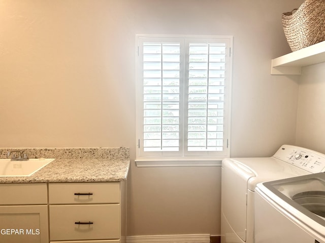 clothes washing area featuring cabinets, independent washer and dryer, and sink