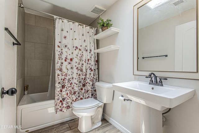 bathroom featuring hardwood / wood-style flooring, toilet, and shower / bath combo with shower curtain