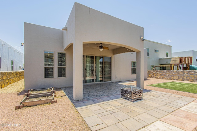 rear view of house featuring ceiling fan, a patio, and a fire pit