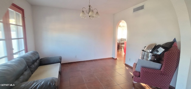 sitting room with dark tile patterned floors and a chandelier