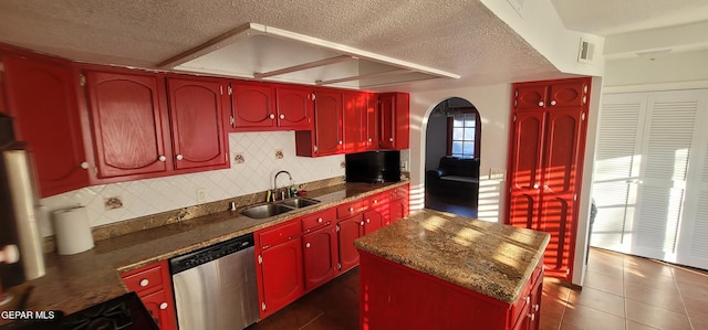 kitchen with a kitchen island, sink, decorative backsplash, stainless steel dishwasher, and a textured ceiling