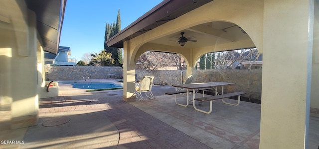 view of patio featuring a fenced in pool and ceiling fan