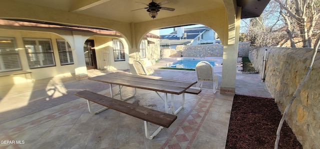 view of patio with a fenced in pool and ceiling fan