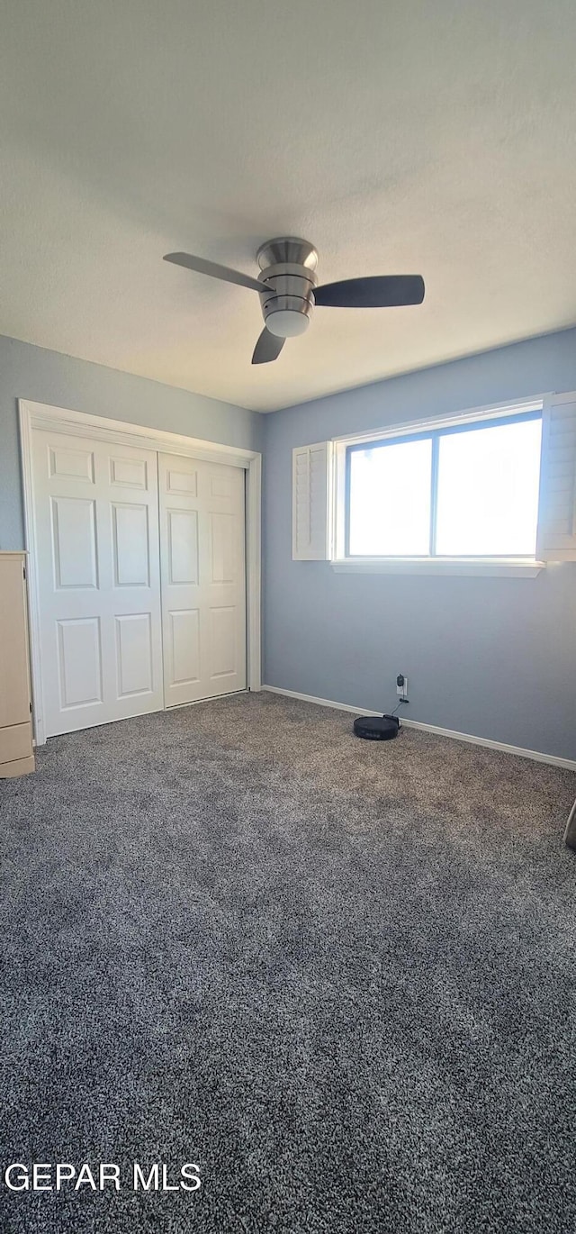 unfurnished bedroom featuring ceiling fan, carpet floors, and a closet