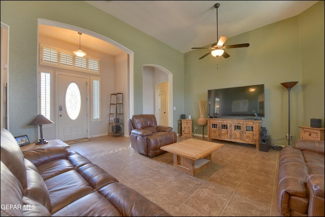 living room with ceiling fan and a high ceiling