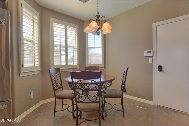 dining area with an inviting chandelier and tile patterned flooring