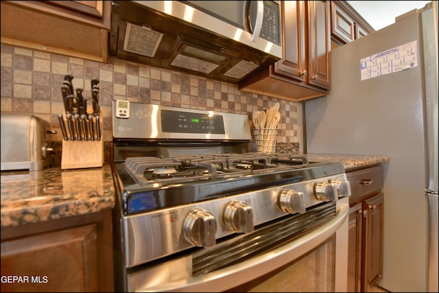 kitchen featuring backsplash, stone counters, and appliances with stainless steel finishes