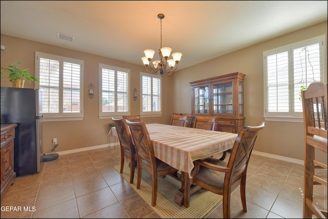 dining room featuring an inviting chandelier and light tile patterned floors