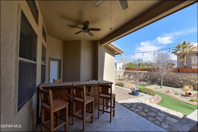 view of patio with an outdoor bar and ceiling fan