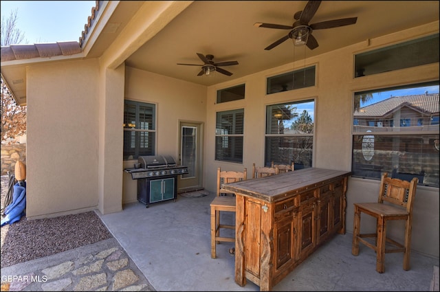 view of patio / terrace featuring a grill, an outdoor bar, and ceiling fan