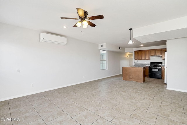 kitchen featuring a center island, black gas stove, a wall unit AC, pendant lighting, and ceiling fan