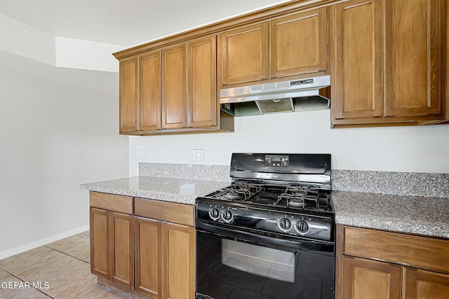 kitchen with light tile patterned flooring, black range with gas stovetop, and light stone counters