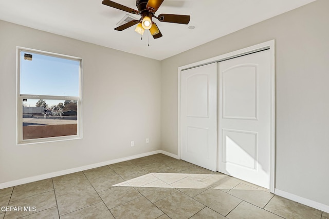 unfurnished bedroom with ceiling fan, a closet, and light tile patterned floors