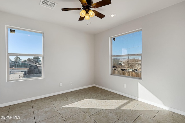 tiled spare room featuring ceiling fan