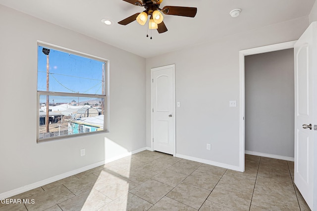 empty room featuring light tile patterned floors and ceiling fan