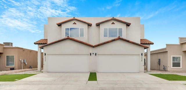 mediterranean / spanish-style house with a garage