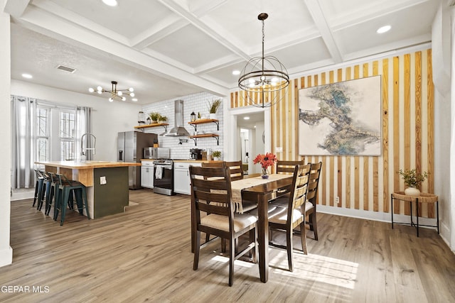 dining area featuring sink, coffered ceiling, a notable chandelier, light hardwood / wood-style floors, and beam ceiling