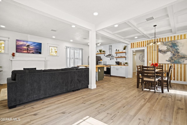 living room featuring coffered ceiling, plenty of natural light, beam ceiling, and light hardwood / wood-style floors