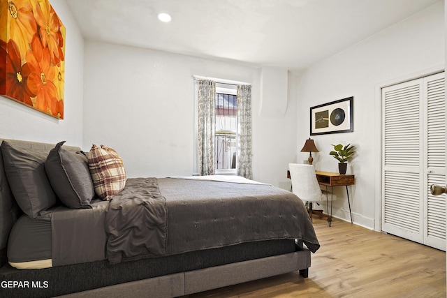 bedroom with light hardwood / wood-style floors and a closet