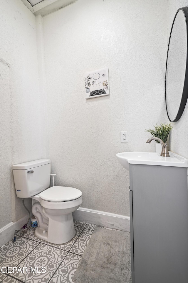 bathroom featuring vanity, tile patterned flooring, and toilet