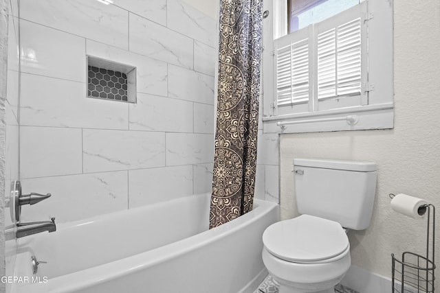 bathroom featuring shower / tub combo and toilet