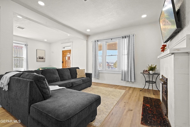 living room with light hardwood / wood-style flooring and a textured ceiling