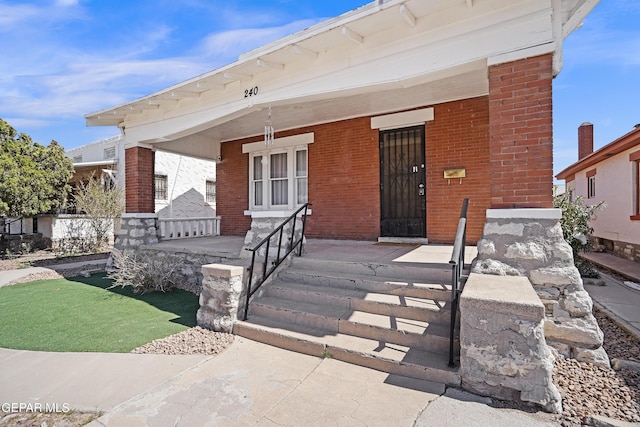 view of front facade with covered porch and brick siding