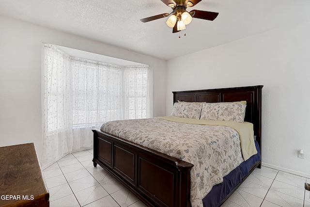 tiled bedroom with a textured ceiling and ceiling fan